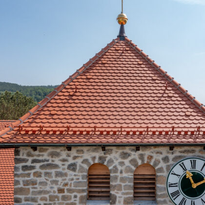 Verstärkter süddeutscher Biber Rundschnitt auf Pfarrkirche in Waffenbrunn im Bild der Biberfirst konisch und Lüfterziegel.