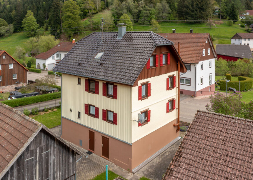 Krüppelwalmdach mit J11v in edelbraun auf saniertem Wohnhaus in der Gesamtansicht.