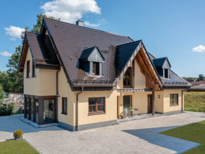 Biber Rundschnitt in edelmarone auf Walmdach/Satteldach eines Einfamilenhauses in der Gesamtansicht.