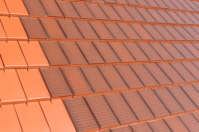Surface covered with Stylist-PV solar roof tiles in red-brown