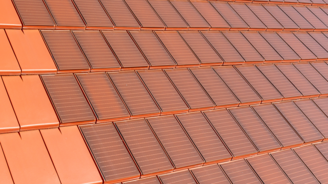 Surface covered with Stylist-PV solar roof tiles in red-brown