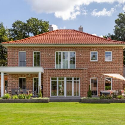 Anmutige Klinkervilla mit Flachdachziegel und Schmuckfirst mit einladender Terrasse.