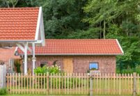 Modernes Bauernhaus mit edlem J11v in edelkupfer und Holzlattenzaun.