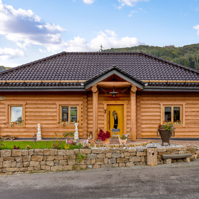 Rustikales Holzhaus mit Flachdachziegel J13v in vulkanschwarz