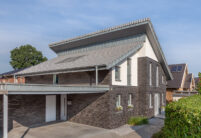 Rear view of a shed roof house with J13v flat roof tile in silver-grey