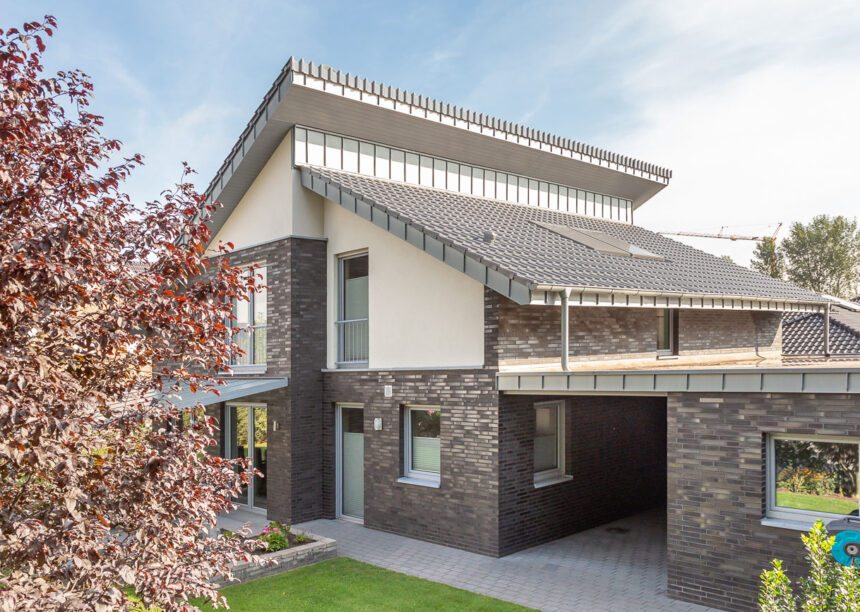 Modern detached house with mono-pitch roof, covered with silver-grey flat roof tile J13v
