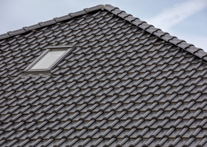 Detailed view of a roof covered with flat roof tile J13v in matt slate grey and ridge F6v