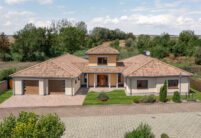 Mediterranean style bungalow with Romanesque pan Marko Bella Casa with brick details.