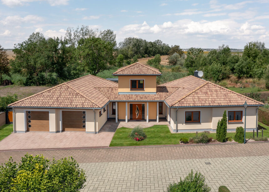 Mediterranean style bungalow with Romanesque pan Marko Bella Casa with brick details.