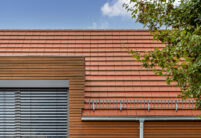 Detached house with wooden elements and the WALTHER Stylist flat tile in red-brown on the roof