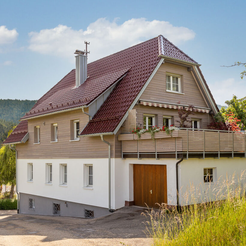 Einfamilienhaus mit Holzelementen und Flachdachziegel W6v in edelrosso auf dem Dach