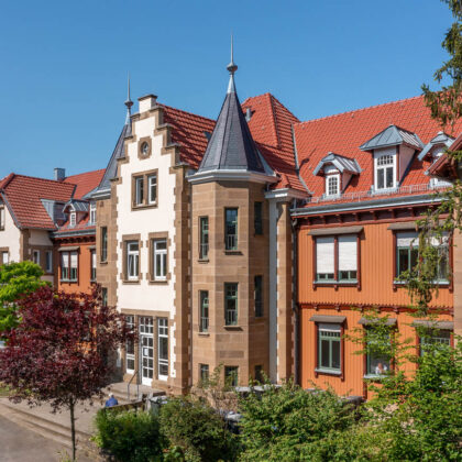 Erholungshaus Seniorenresidenz mit Doppelmuldenfalzziegel Tradition in rotbraun frontale Ansicht.