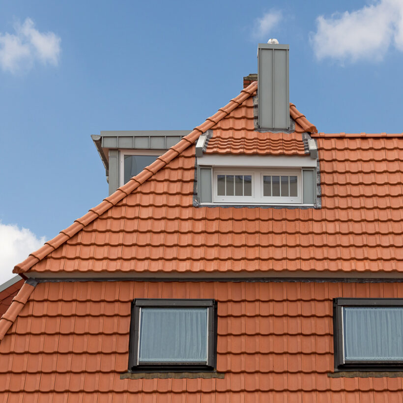 Refurbished detached house with mansard roof in natural red