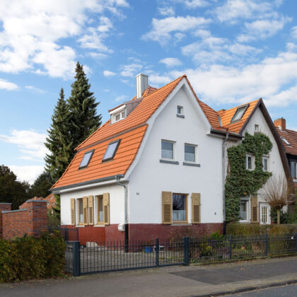 Refurbished detached house with mansard roof in natural red