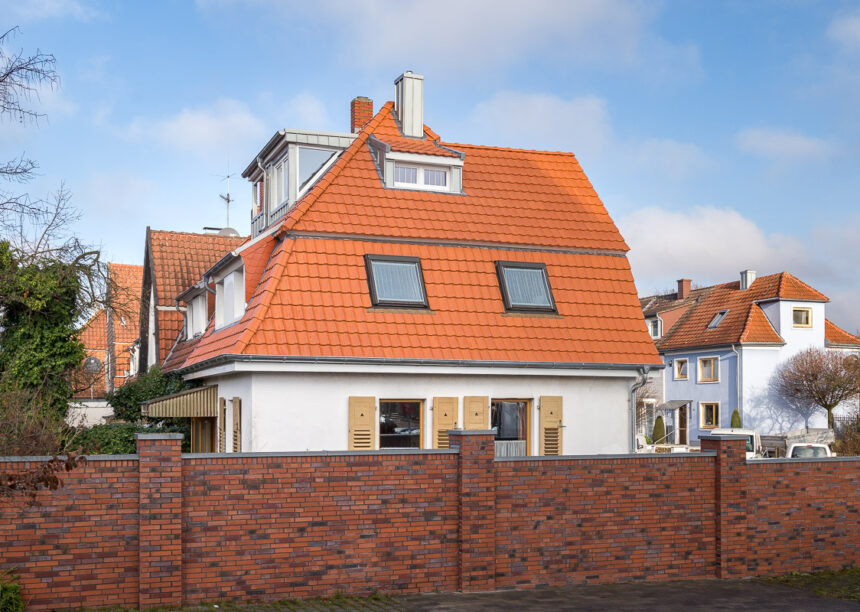Refurbished detached house with mansard roof in natural red